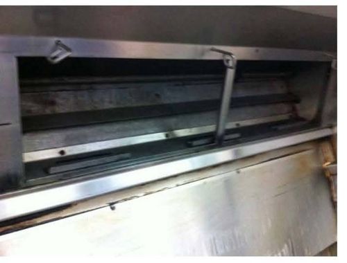Commercial kitchen exhaust canopy with restored stainless steel after cleaning