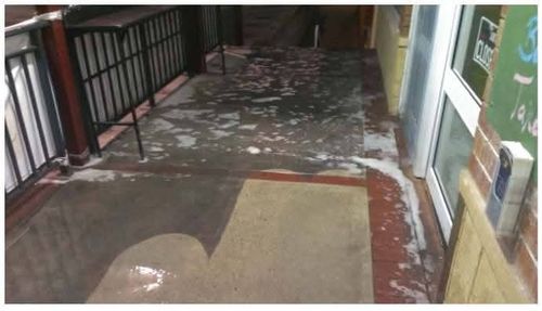 Commercial paving with dirt and staining before high-pressure cleaning